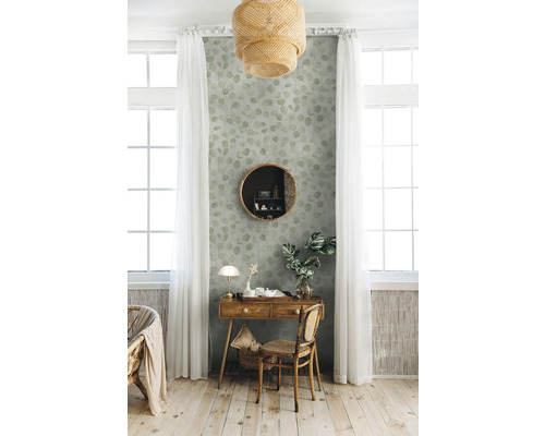 Decoratief interieur met een houten tafel, een ronde spiegel en een behang met bladerpatroon in een lichte kamer