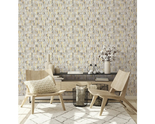 Een woonkamer met geometrisch behang, twee houten stoelen en een tapijt.