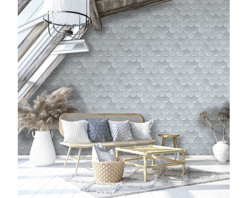 Woonkamer met geschubd behang, rotanmeubels en decoratieve accessoires onder een dakraam