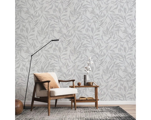 Woonkamer met fauteuil, staande lamp en wandbehang met bladerpatroon