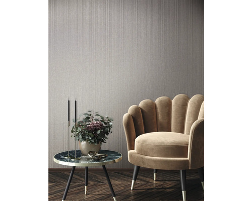 Scene met een wandbekleding, een fauteuil en een bijzettafel met decoratie