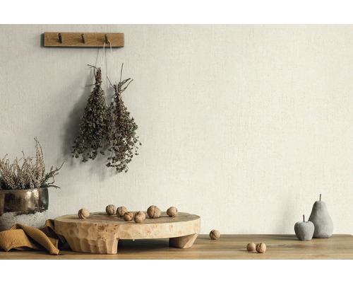 Decoratieve scène met planten, noten en houten objecten op een tafel voor een wand