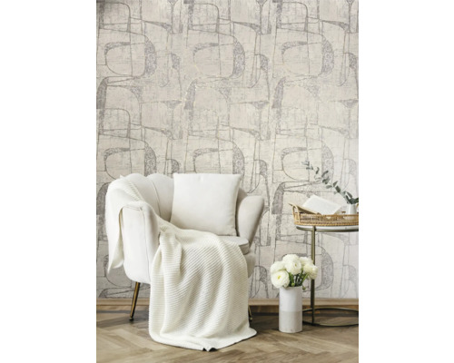 Lichte woonkamer met fauteuil, deken, kussen, bijzettafel, bloemen en patroonbehang
