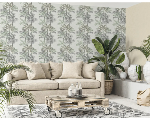 Woonkamer met palmpatroonbehang, bank, planten en salontafel van pallets