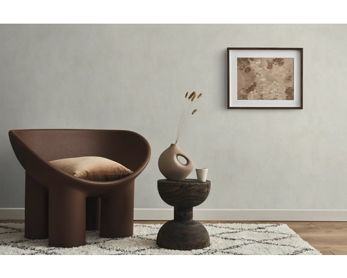 Woonkamer met fauteuil, kussen, bijzettafel, decoratie en ingelijste afbeelding