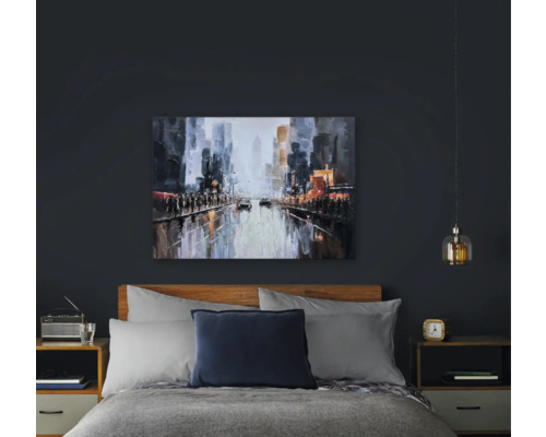 Slaapkamer met bed, nachtkastjes en een schilderij met stadsgezicht boven het bed.
