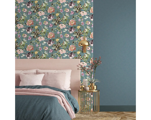 Decoratieve slaapkamer met bloemenbehang, bed en bijzettafel.