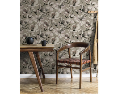 Woonkamer met eettafel, stoel en behang met bloemmotief.