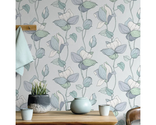 Bloemenbehang met theepot en potplant op houten tafel