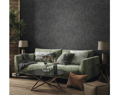 Woonkamer met groene bank, salontafel en behang met motief