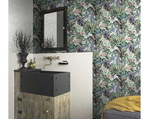 Een badkamer met bloemetjesbehang, een wastafel op een houten sokkel en een spiegel