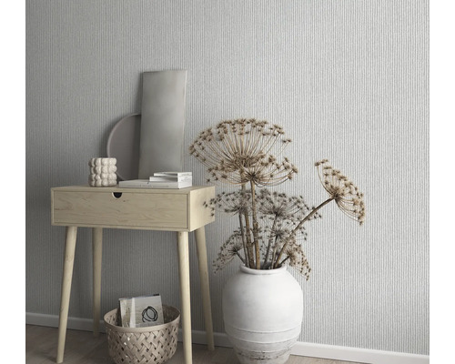 Decoratieve scène met een kleine houten tafel, vaas met droogbloemen en patroonbehang