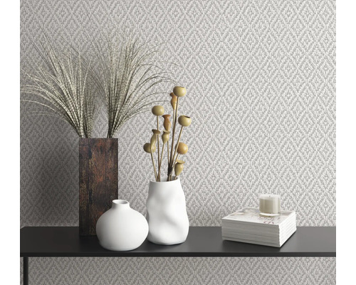 Decoratief interieur met patroonbehang, vazen, decoratie en kaars op een zwart oppervlak.