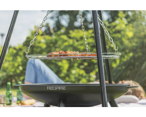 Driepootbarbecue met gegrild eten en RedFire logo voor outdoor barbecueplezier