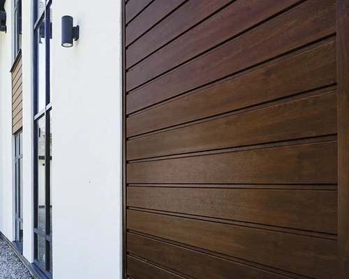 Buitenkant van een huis met houten gevelbekleding en ramen