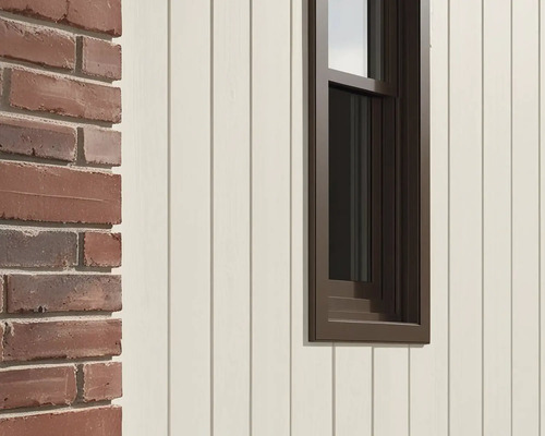 Detailopname van een gevel met bakstenen muur, houten bekleding en raam