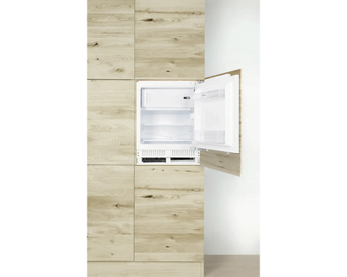 Ingebouwde koelkast met open deur in een houten keuken
