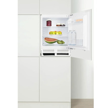 Ingebouwde koelkast met open deur, gevuld met levensmiddelen in witte keuken