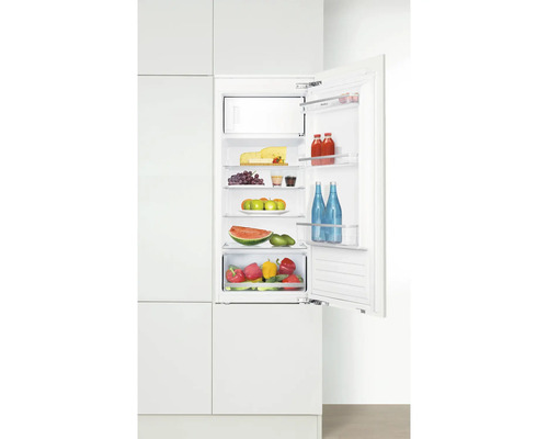 Geïntegreerde koelkast met open deur, gevuld met levensmiddelen zoals kaas, fruit en groenten.