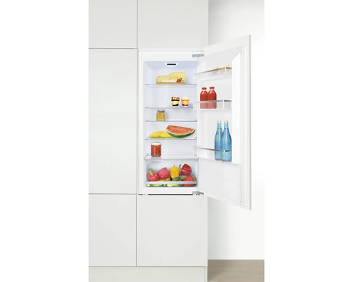 Geopende inbouwkoelkast gevuld met boodschappen in een heldere keuken