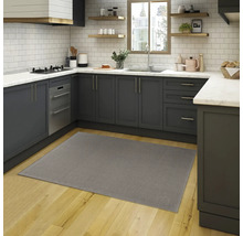 Grijs tapijt in een moderne keuken met grijze kasten en een houten vloer.