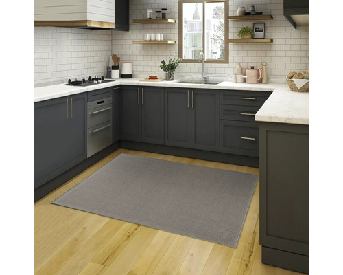 Grijs tapijt in een moderne keuken met grijze kasten en een houten vloer.