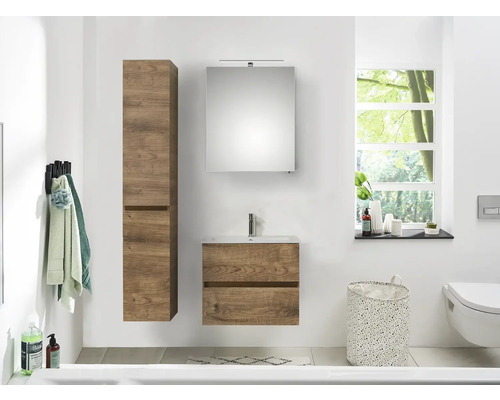 Lichte badkamer met houten wastafelonderkast, spiegelkast en hoge kast.