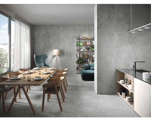 Lichte woonkamer met eettafel, stoelen, rekken, tegels en groot raam.