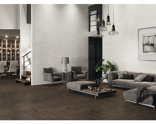 Ruime woonkamer met bruine vloertegels en lichte wandtegels, ingericht met grijze meubels.