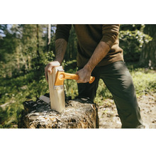 Man hakt hout met een Fiskars kloofbijl op een boomstronk