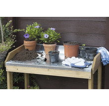 Tuiniertafel met bloempotten, potgrond, handschoenen en een tuinschep