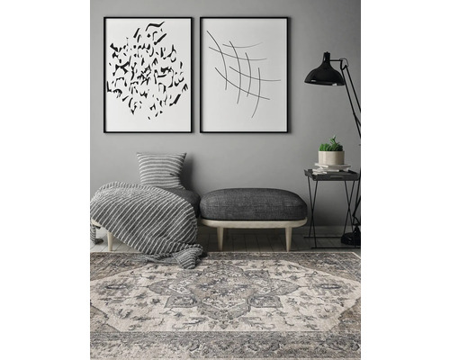 Decoratieve woonkamer met vloerkleed, voetenbank en muurkunst.