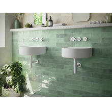 Moderne badkamer met twee ronde wastafels en groene wandtegels.