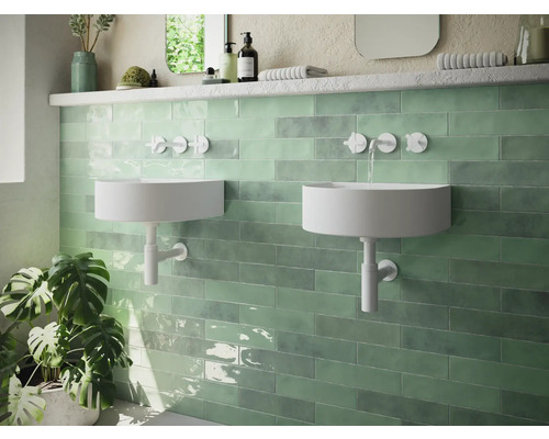 Moderne badkamer met twee ronde wastafels en groene wandtegels.