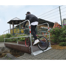Man fietst met BMX over een tijdelijke brug.