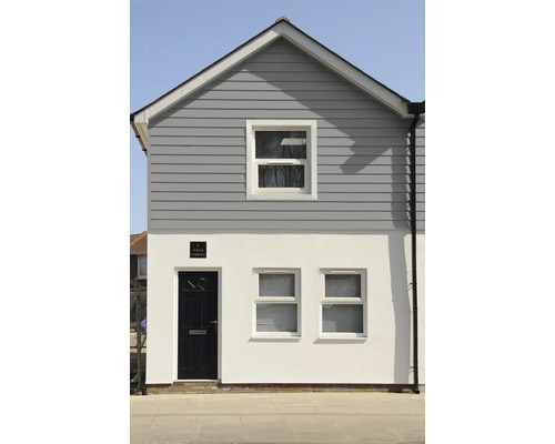 Gevel van een huis met ramen, een deur en gevelbekleding