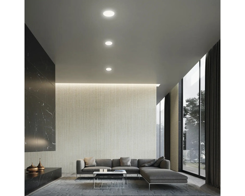 Woonkamer met inbouwspots, bank en raampartij