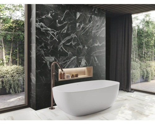 Badkamer met bad, zwarte marmeren wand en groot raam