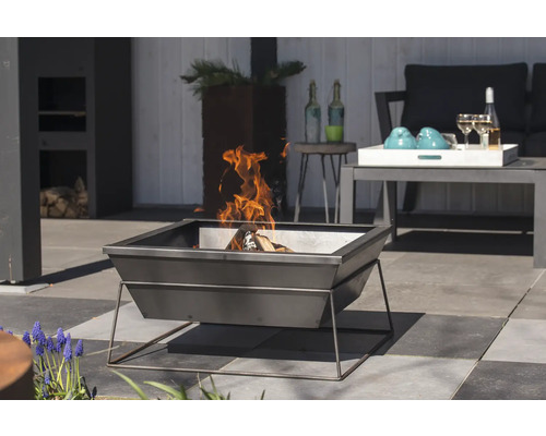 Vierkante vuurschaal van metaal met brandend hout buitenshuis