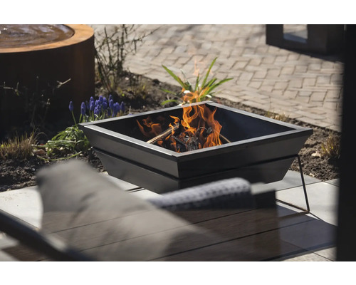 Vierkante metalen vuurschaal met brandend hout buitenshuis.