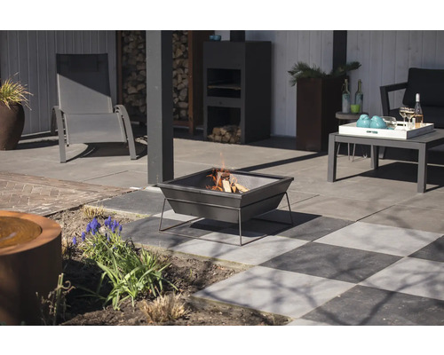 Terrasopstelling met vuurkorf, tuinmeubelen en decoratieve elementen.