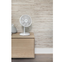 Scene met een tafelventilator op een houten kast voor een gestructureerd behang.