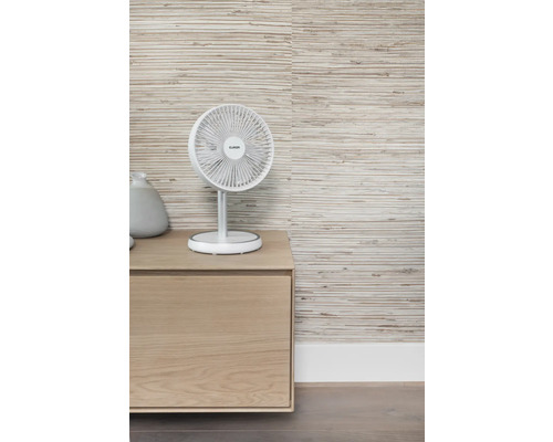 Scene met een tafelventilator op een houten kast voor een gestructureerd behang.