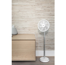 Staande ventilator naast een houten kast voor een wand met motief