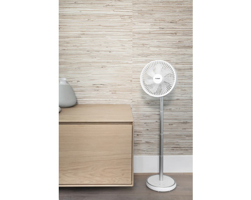 Staande ventilator naast een houten kast voor een wand met motief