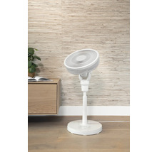 Witte staande ventilator naast een kast