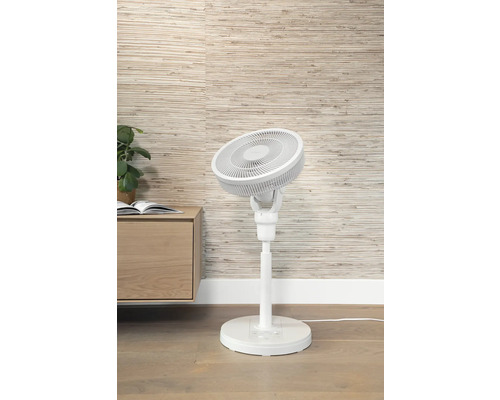 Witte staande ventilator naast een kast