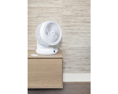 Witte Eurom ventilator met afstandsbediening op een nachtkastje