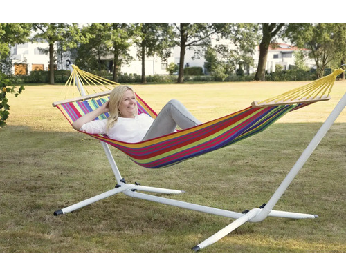 Vrouw ontspant in gestreepte hangmat met frame in de tuin.