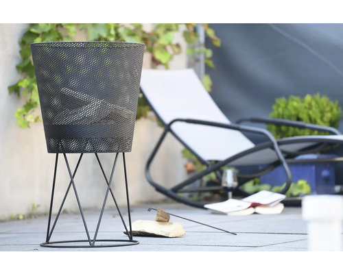 Decoratieve vuurschaal van metaal voor buiten, met ligstoel op de achtergrond